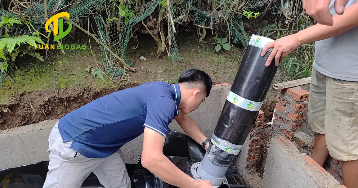 Kỹ thuật viên siết chặt cùm inox cố định ống ruột gà bọc bạt HDPE vào mặt bích túi
