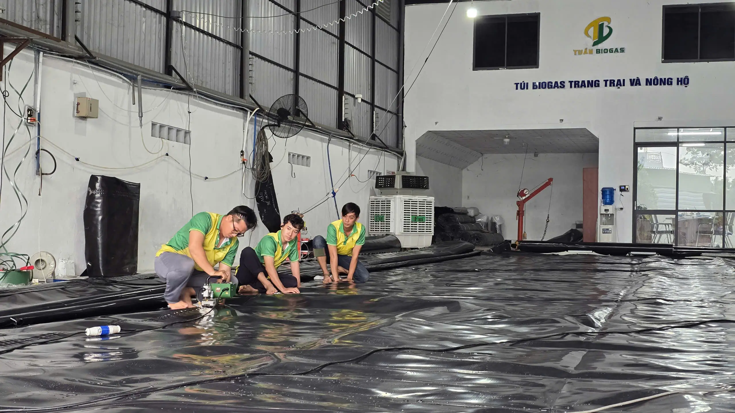 Kỹ thuật viên cắt bạt túi biogas theo kích thước tùy chỉnh tại xưởng